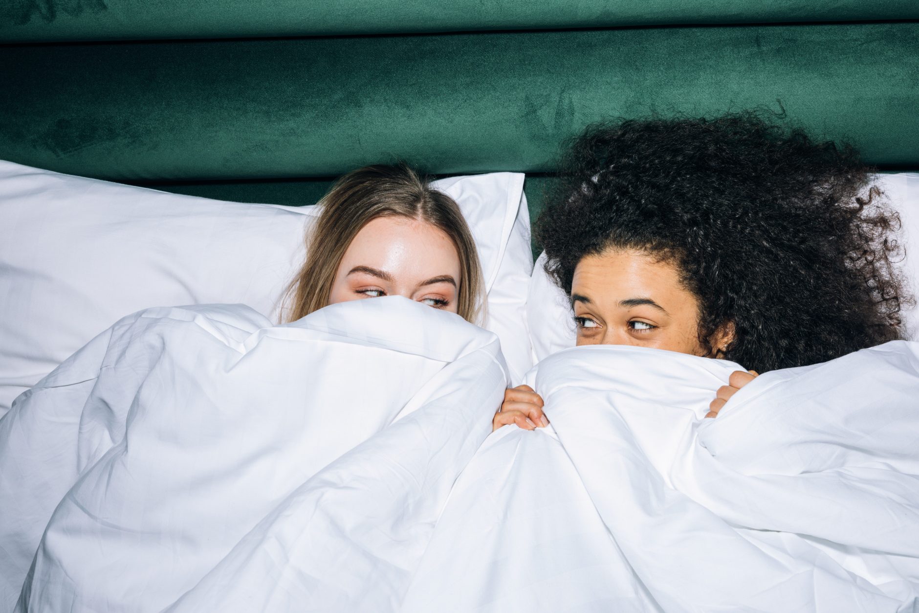 two girls having fun under blanket