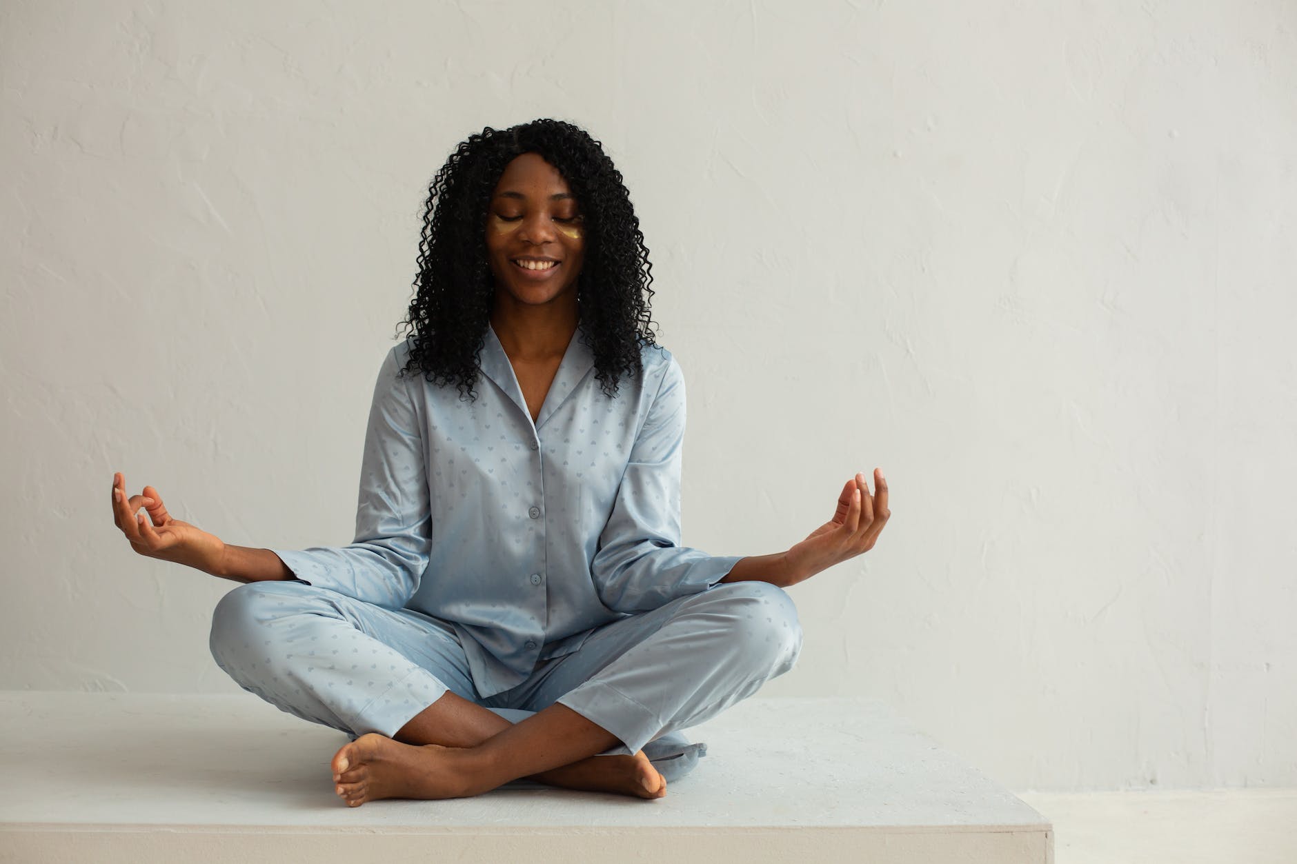 Meditating coloured woman in pyjama