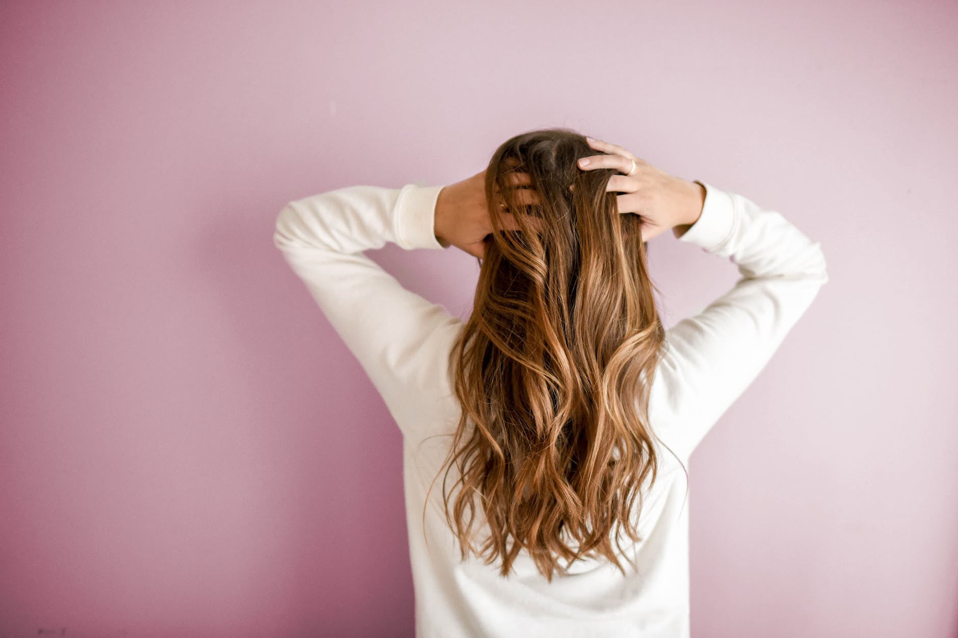 woman going through her hair with her hands